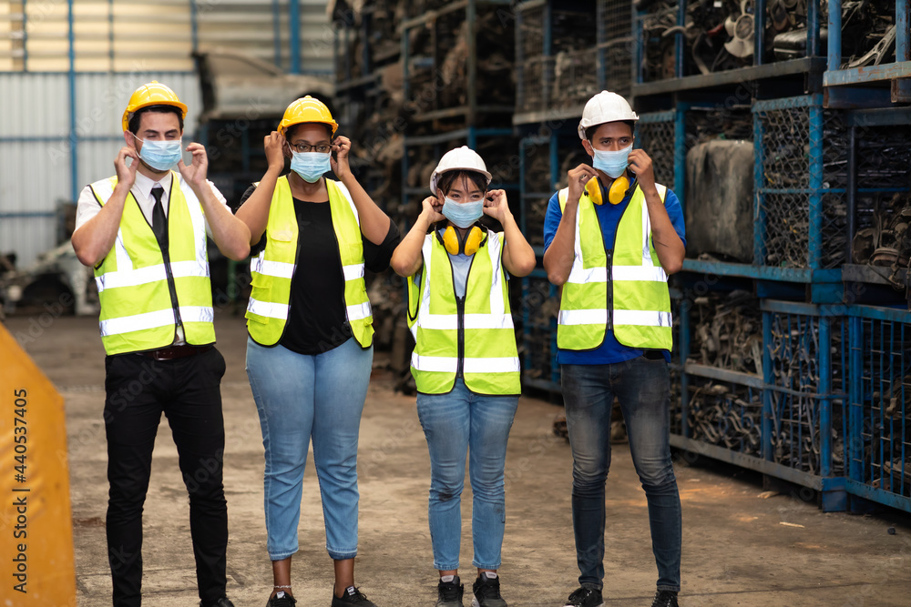 Obraz premium Engineer factory people wearing protective face mask prevent covid-19 virus. Professional Mechanical Engineer team Working at Second-hand spare parts of old car parts warehouse store.