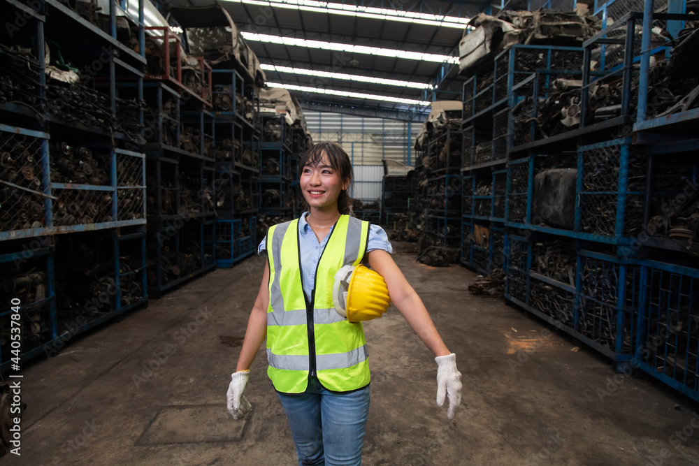Fototapeta premium Portrait warehouse managers or worker asian woman working at large distribution warehouse of old car part.