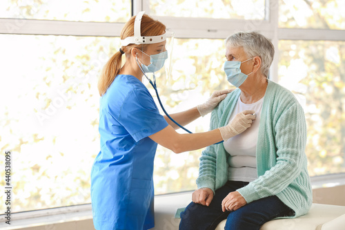 Doctor examining senior wom...