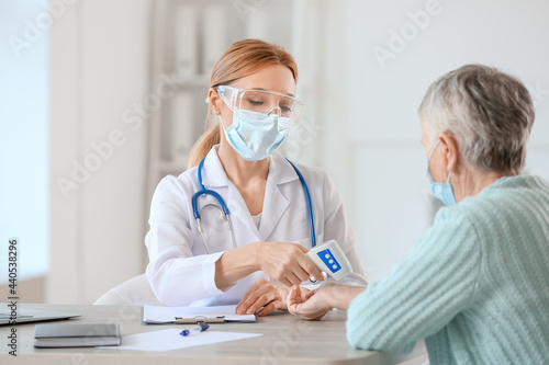 Doctor measuring temperatur...