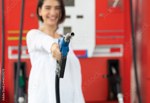 Attractive young woman refueling her car in a gas station