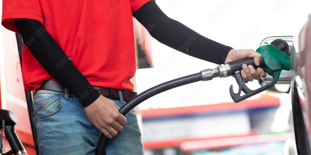 Man worker hand holding nozzle and refuel the car Man worker hand holding nozzle and refuel the car