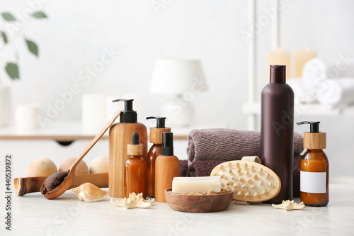 Spa set with bottles of cosmetics on light background