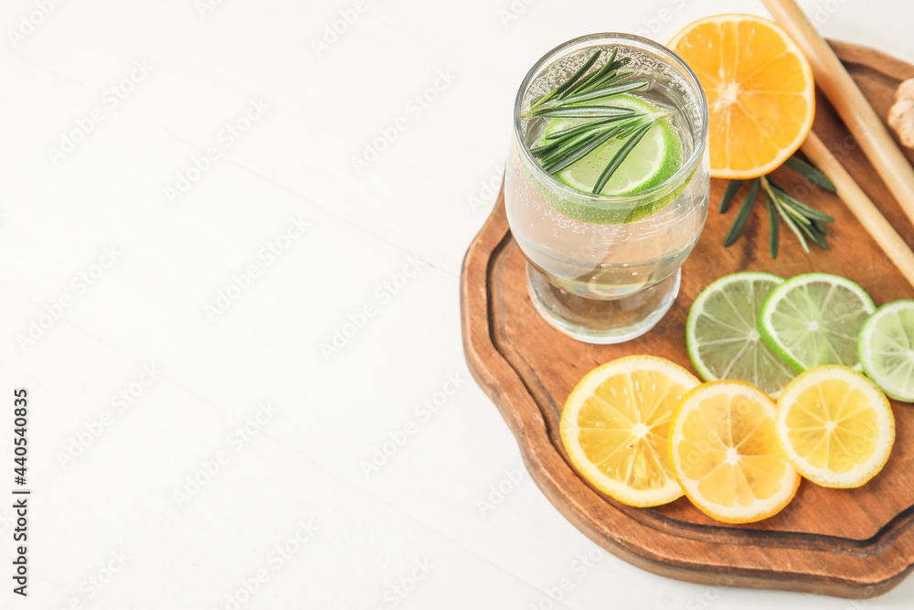 Glass of healthy lemonade and citrus fruits on white background Glass of healthy lemonade and citrus fruits on white background