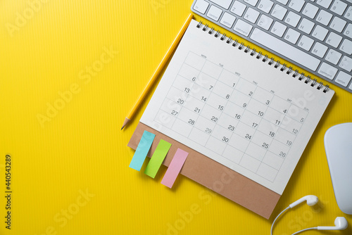 close up of calendar and computer keyboard on the yellow table background, planning for business meeting or travel planning concept