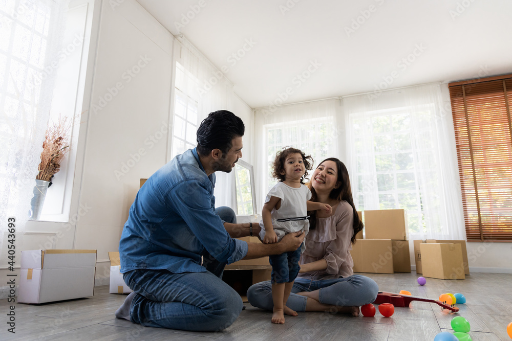 Happy family in living room. Cute daughter with parent. Moving new house a lot of parcel box. Father mother and daughter relax together at home in the morning. Happy family in living room. Cute daughter with parent. Moving new house a lot of parcel box. Father mother and daughter relax together at home in the morning.