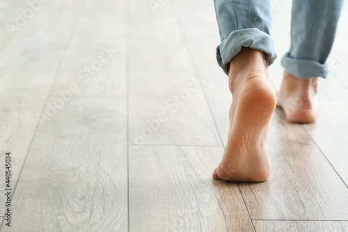 Foto Man walking on new laminate flooring at home