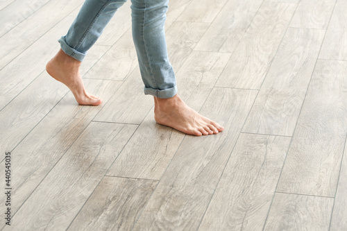 Man walking on new laminate flooring at home photo
