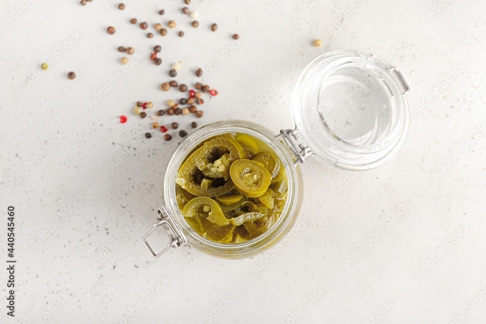 Glass jar with canned jalapeno on light background Glass jar with canned jalapeno on light background