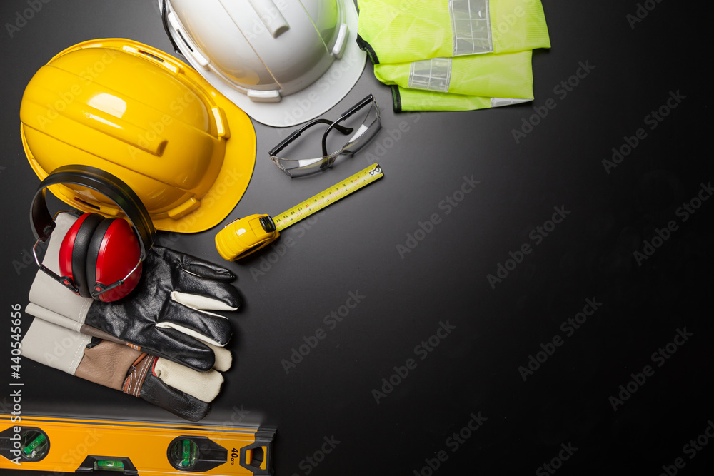 Work safety. Construction site protective equipment on wooden background, flat lay, copy space, top view - obrazy, fototapety, plakaty 