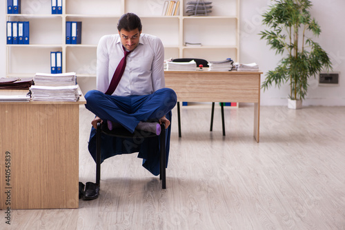 Young male employee doing yoga exercises during break