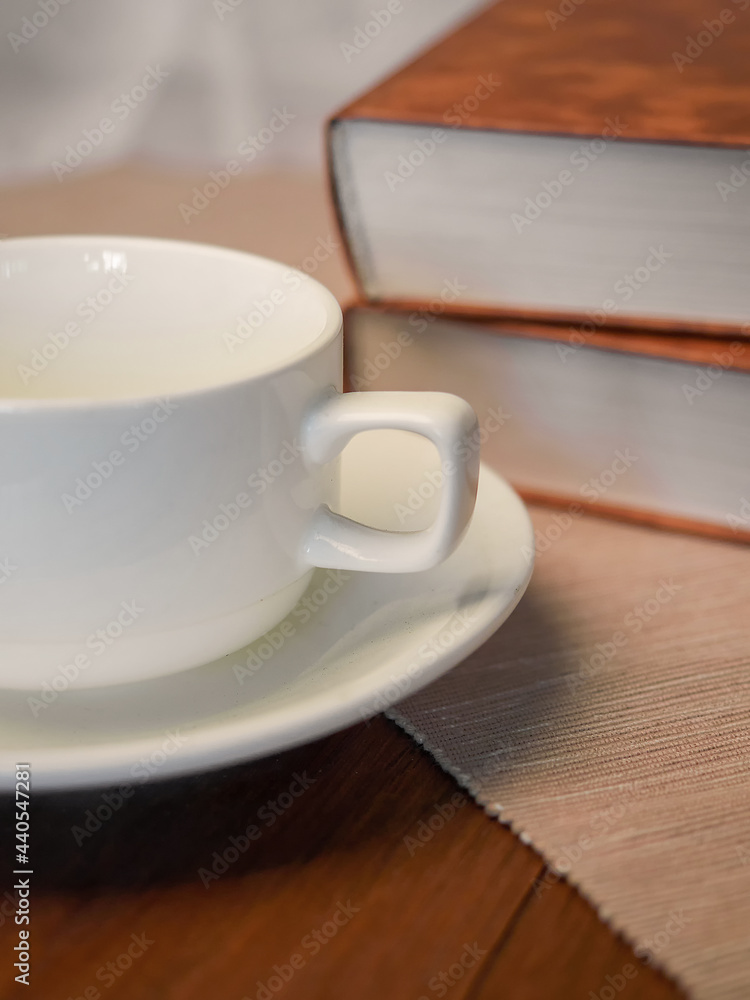 The concept of teaching education with the opening of a book or textbook in the library. a cup of fresh coffee on the table. The concept of teaching education with the opening of a book or textbook in the library. a cup of fresh coffee on the table.