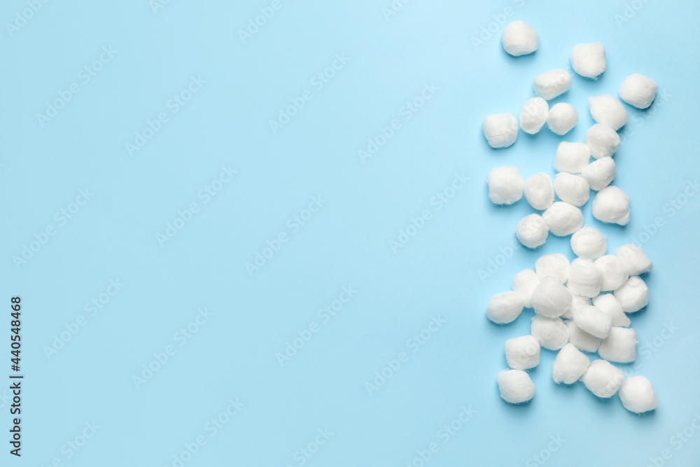 Soft cotton wool balls on color background