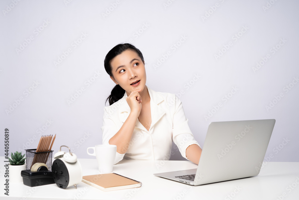 Asian woman happy smiling in white shirt working on a laptop at office. Asian woman happy smiling in white shirt working on a laptop at office.