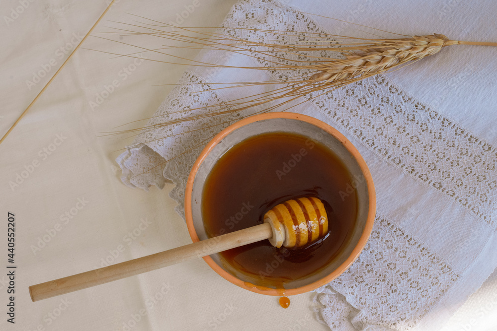 Honey in a ceramic saucer on a white napkin. Honey in a ceramic saucer on a white napkin.