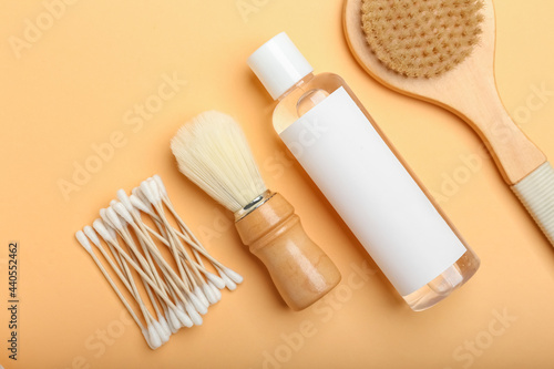 Cotton swabs  brushes and bottle of cosmetic product on color background