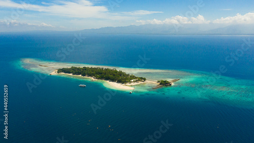Tropical Little Liguid Island in the blue sea with beaches and palm trees. Little Cruz Island, Philippines, Samal.