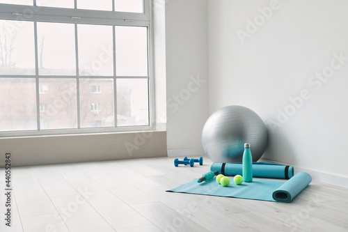 Fototapeta Naklejka Na Ścianę i Meble -  Set of sports equipment with fitness ball near light wall