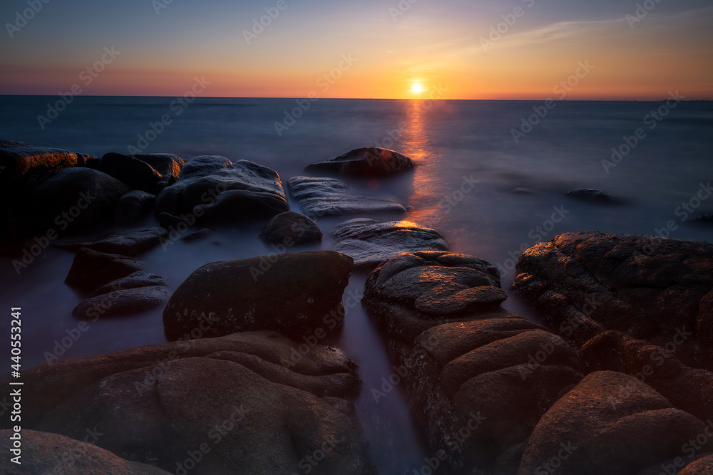 Obraz premium Motion seascape through stone arch at sunset, Rayong