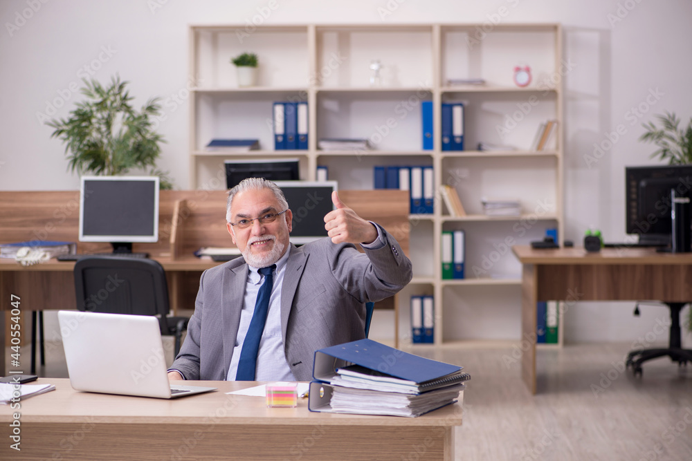 Old male employee working in the office Old male employee working in the office