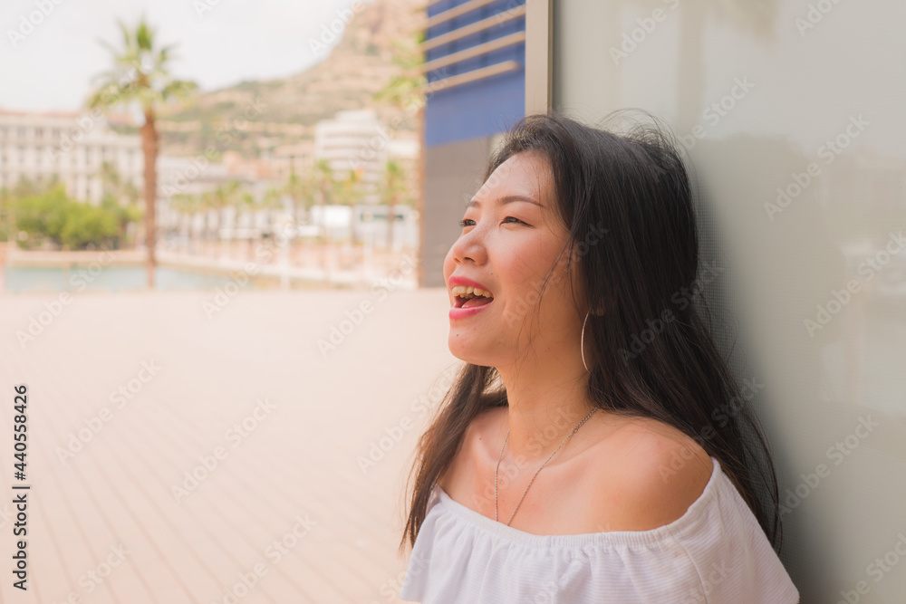 young beautiful Asian woman relaxed outdoors - casual lifestyle portrait of attractive and happy Chinese girl in white summer dress outdoors enjoying sunny day young beautiful Asian woman relaxed outdoors - casual lifestyle portrait of attractive and happy Chinese girl in white summer dress outdoors enjoying sunny day