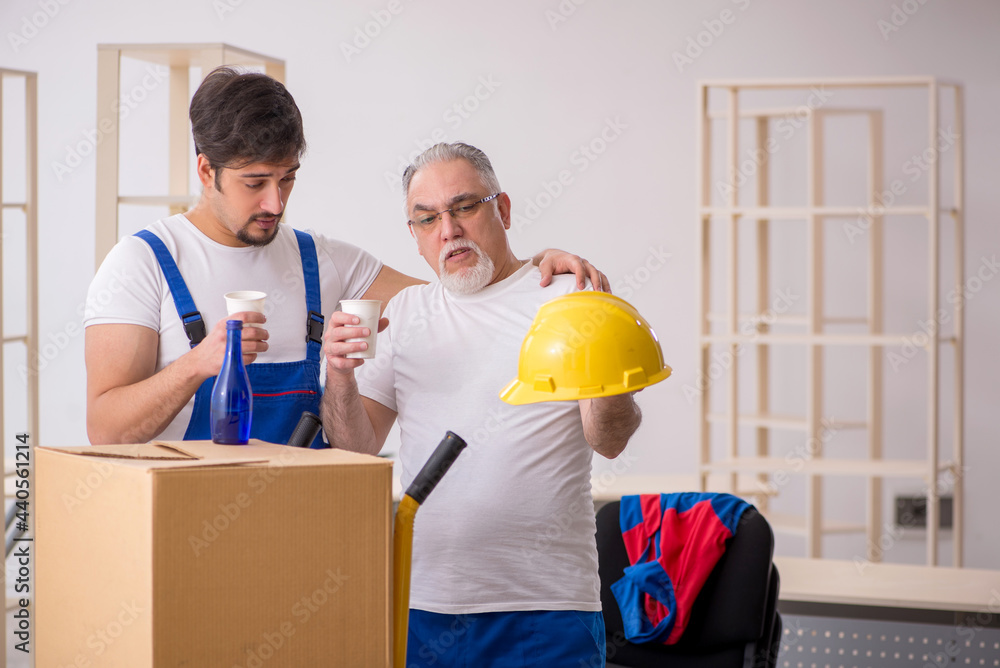 Two male professional movers drinking alcohol during break Two male professional movers drinking alcohol during break