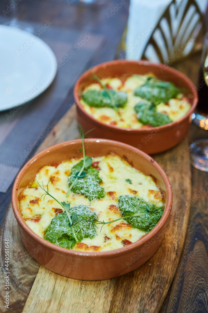 Vegetable casserole with cheese in a rural kitchen. Food in clay dishes Vegetable casserole with cheese in a rural kitchen. Food in clay dishes