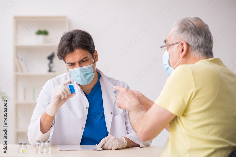 Old male patient visting young male doctor in vaccination concep Old male patient visting young male doctor in vaccination concep