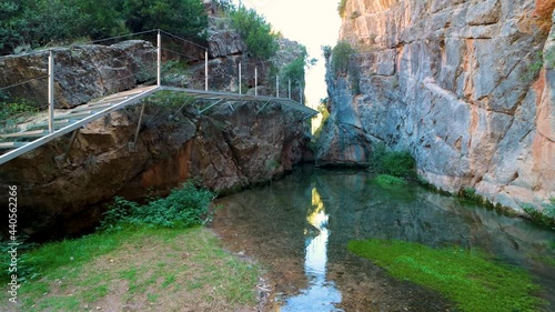 Nice corner of the natural path of the guadalaviar in San Blas, Teruel, with a metal walkway that crosses the river photo