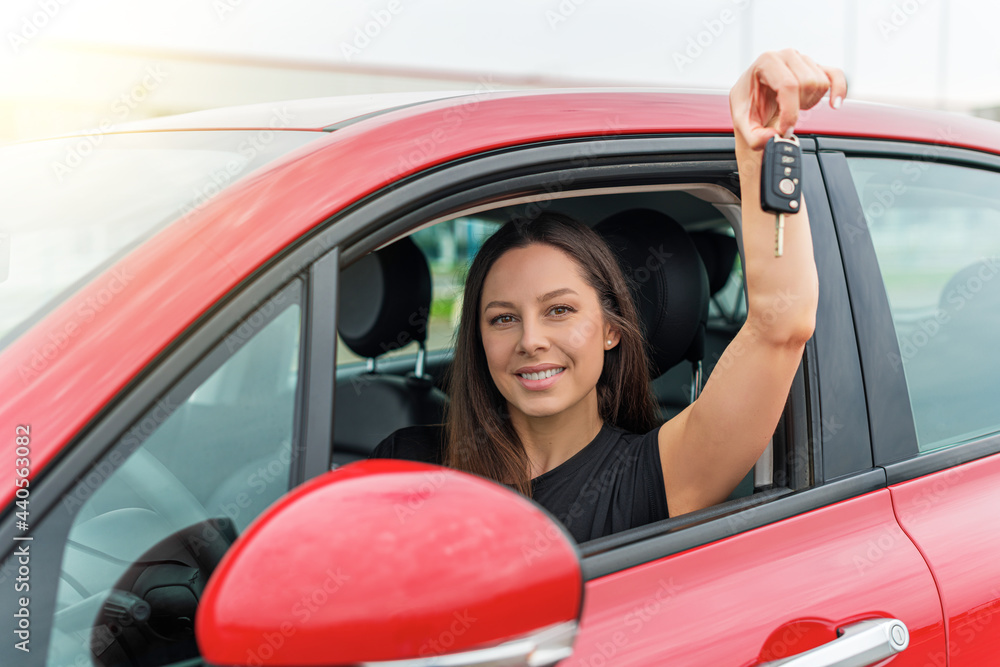 Attractive young woman shows the keys to the car. Beautiful joyful girl in the car. Attractive young woman shows the keys to the car. Beautiful joyful girl in the car.