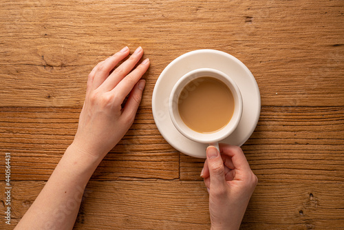 Hands with coffee on the wooden table