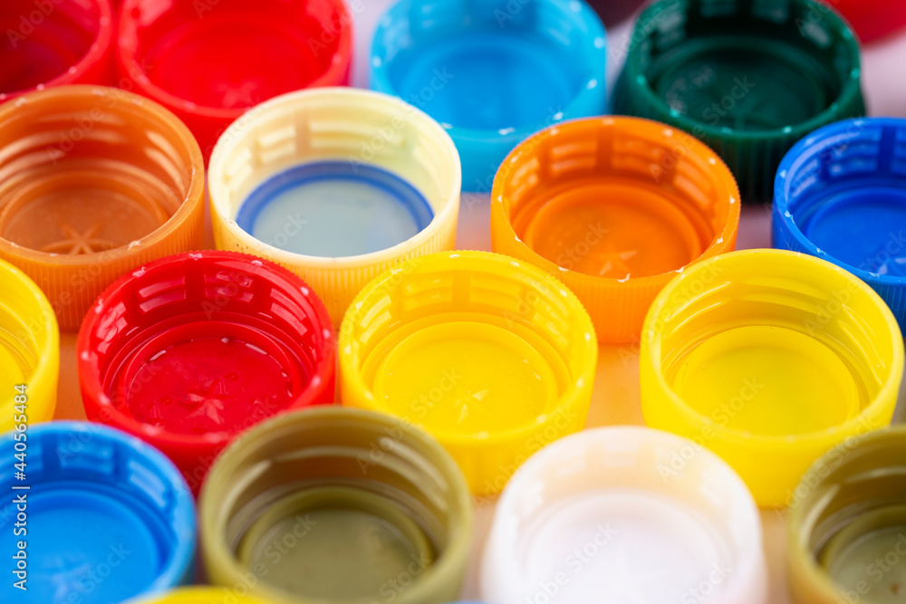 Many multi-colored plastic bottle caps on a white background. Many multi-colored plastic bottle caps on a white background.