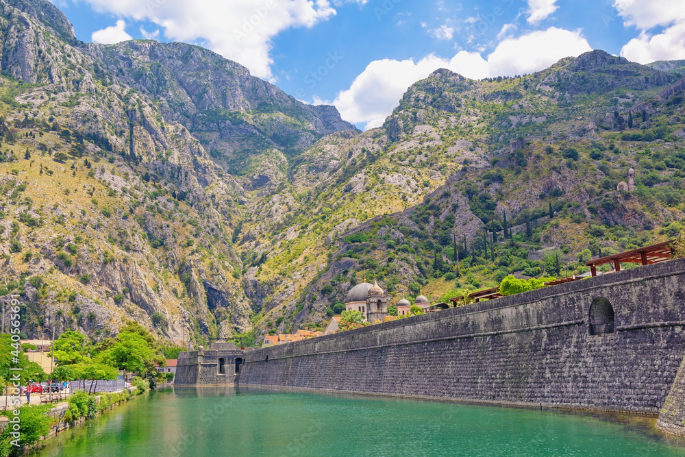 Montenegro, Old Town of Kotor. View of Skurda river and northern walls of ancient fortress on sunny summer day Montenegro, Old Town of Kotor. View of Skurda river and northern walls of ancient fortress on sunny summer day