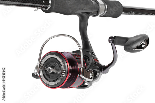 The fishing reel is installed on a rod for catching perch, zander, pike and other predatory fish. Fishing gear. Tackle isolated on white background.