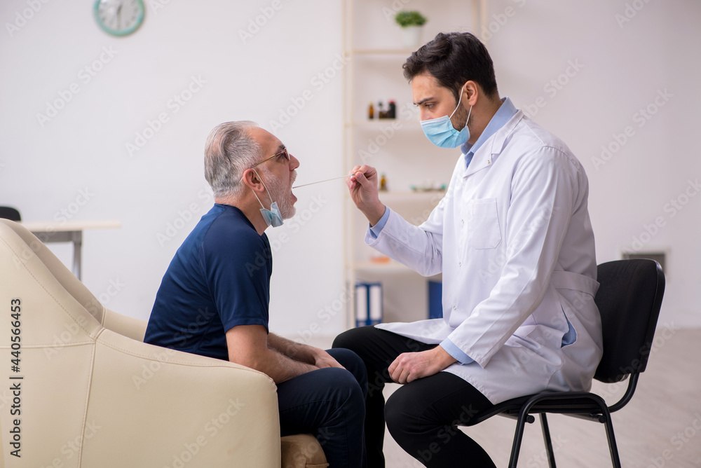 Obraz premium Old male patient visiting young male doctor otorhinolaryngologis