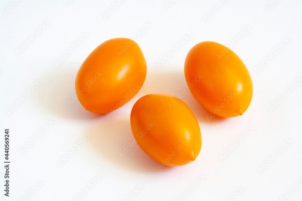 Three yellow tomatoes isolated on a white background Three yellow tomatoes isolated on a white background