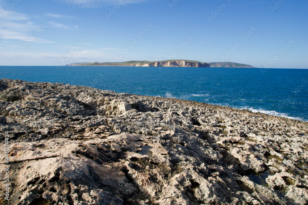 MELLIEHA, MALTA - 01 JAN, 2020: Interesting rock formations along coastline with Mediterranean Sea and Gozo island in the background