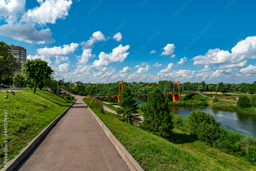 Fototapeta premium Beautiful view on Embankment of the Tsna River in Tambov. Suspension pedestrian bridge in Tambov city