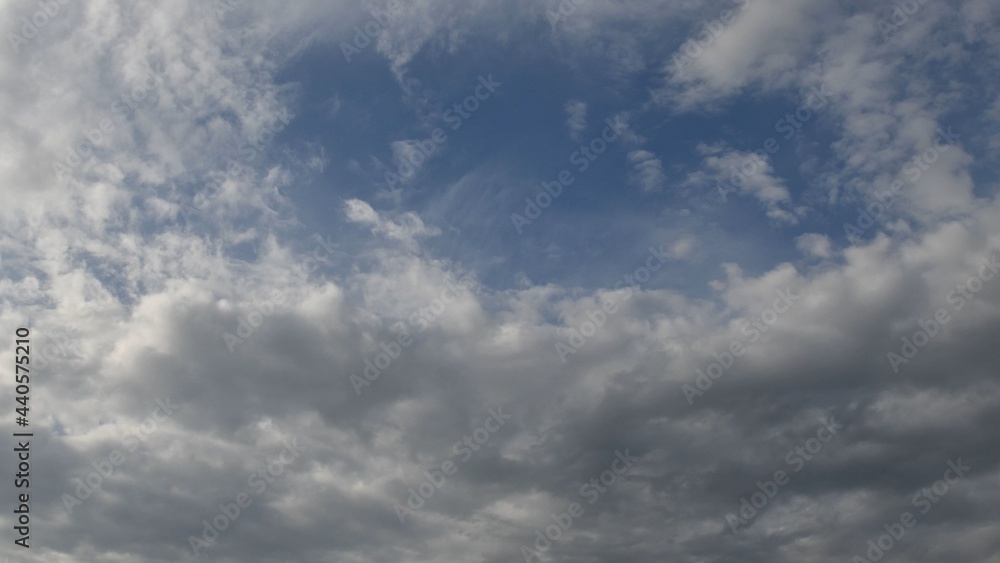 Azure blue sky with white fluffy cumulus clouds floating in wind. Serene cloudscape of summer weather. Altocumulus and cirrocumulus types of clouds Azure blue sky with white fluffy cumulus clouds floating in wind. Serene cloudscape of summer weather. Altocumulus and cirrocumulus types of clouds
