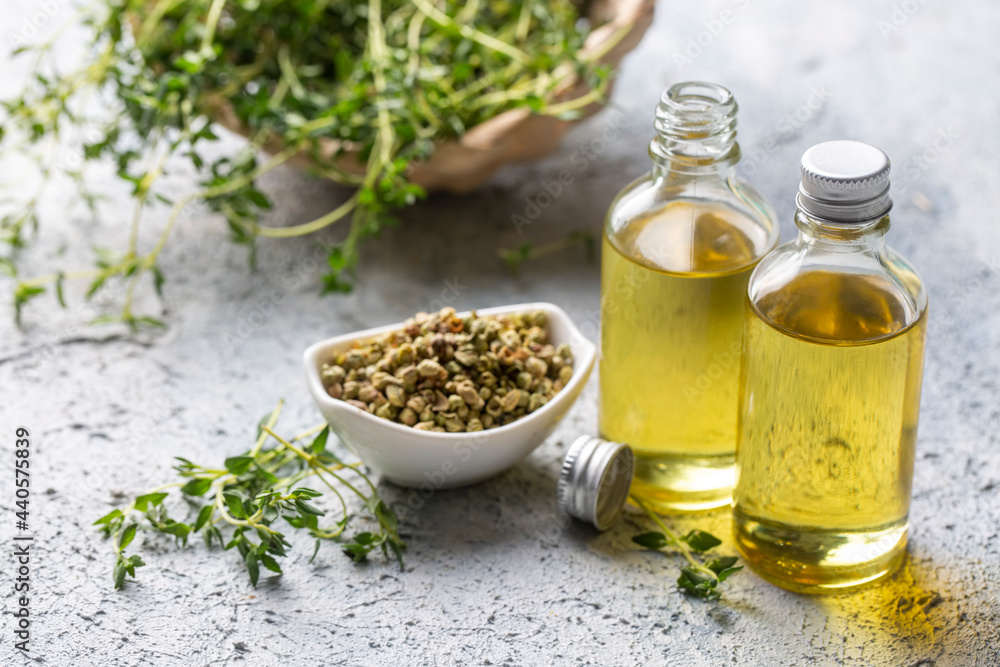 A bottle of thyme essential oil with fresh thyme A bottle of thyme essential oil with fresh thyme