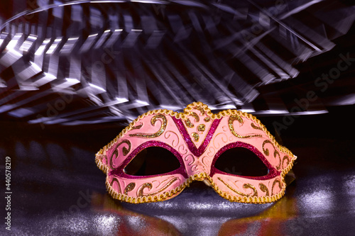 Venetian Masks with white light trails on a black reflective background