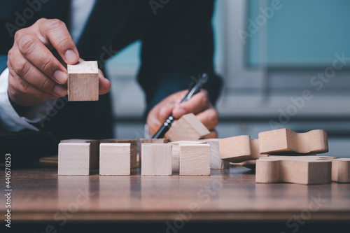 The businessman setting up a wooden cube