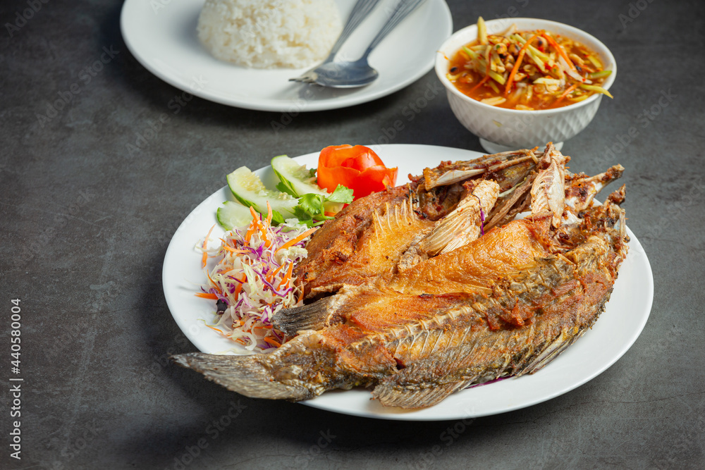 Fried snapper in a plate placed on a black background Fried snapper in a plate placed on a black background