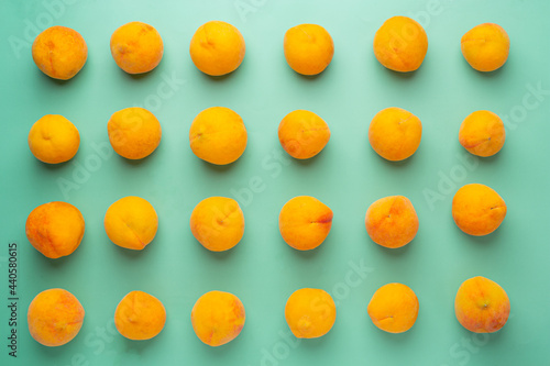 Peaches are placed on a pastel green background.