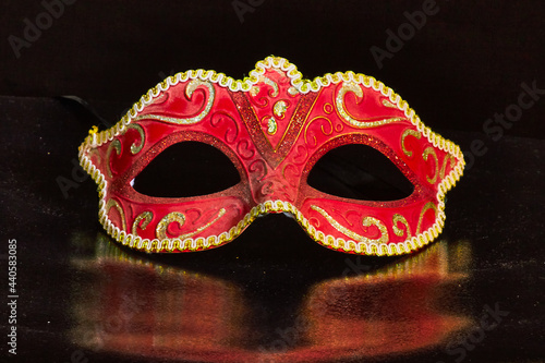 Venetian Masks with white light trails on a black reflective background