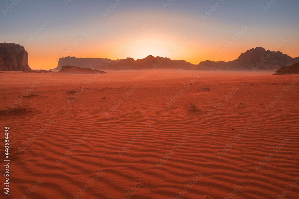 Fototapeta premium Beautiful sunset in the red desert of Wadi Rum in Jordan with patterns on the sand