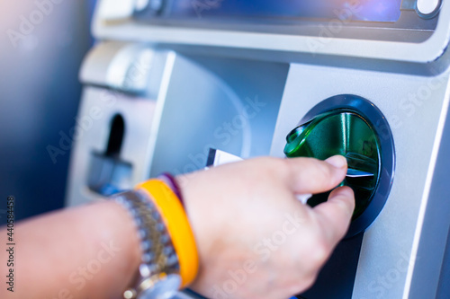 Fotografie Man's Hand Using Card To Withdraw Money