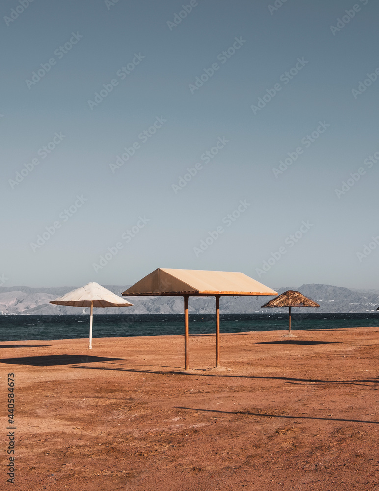 empty beach with umbrellas in the style of minimalism, on the red sea in Jordan Aqaba, south beach. empty beach with umbrellas in the style of minimalism, on the red sea in Jordan Aqaba, south beach.