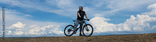 Fototapeta Naklejka Na Ścianę i Meble -  Conquering mountain peaks by cyclist in shorts and jersey on a modern carbon hardtail bike with an air suspension fork .