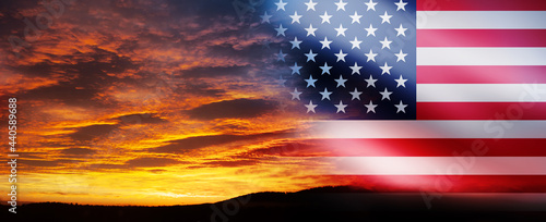 United States of America flag on bright sky at sunset or sunrise background.